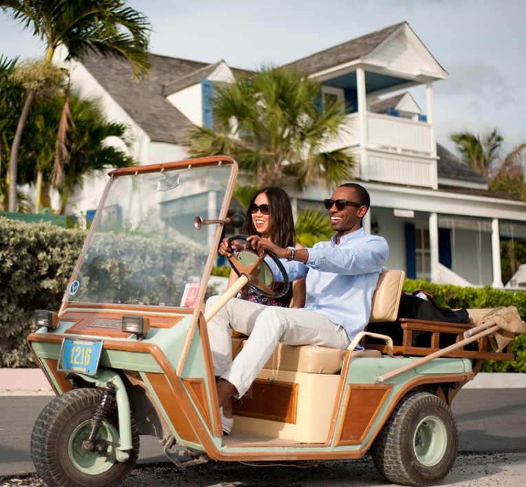 a man and woman driving a small vehicle