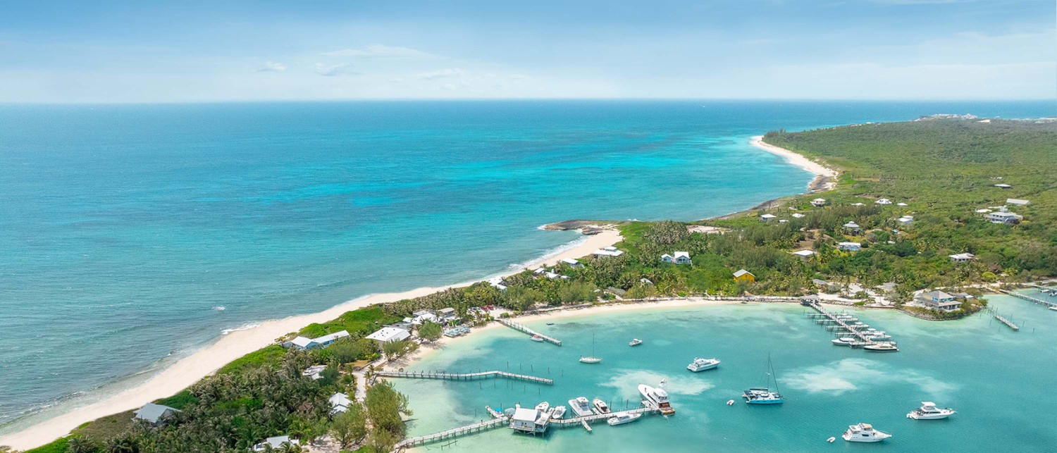 an aerial of a marina on the right side and ocean on the left side
