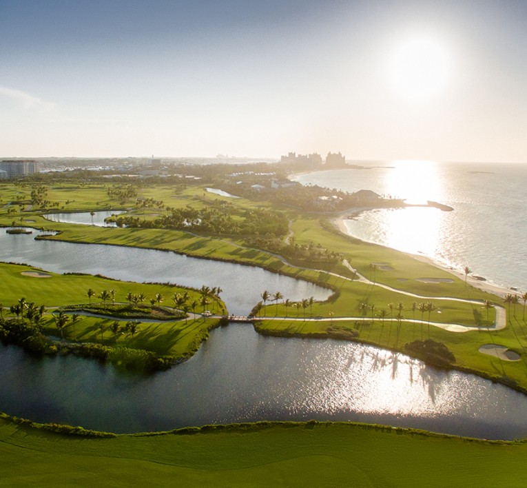 a golf course with water and a body of water