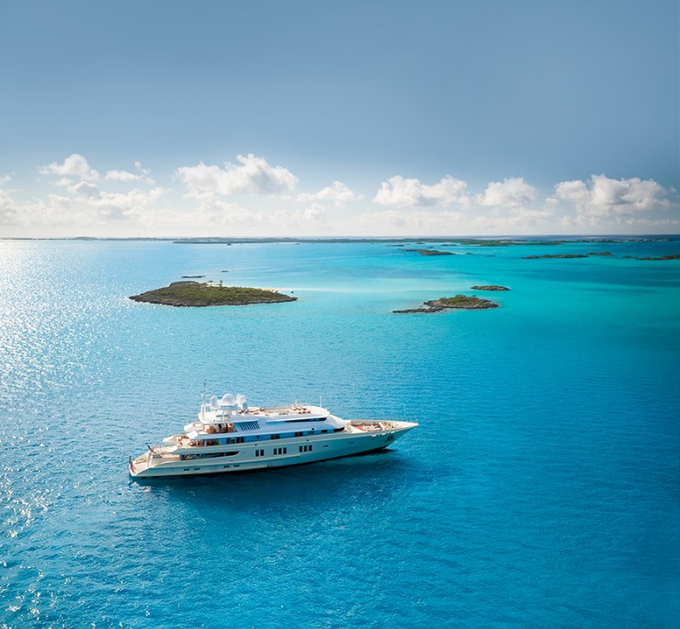 a yacht in the water with cays in the background