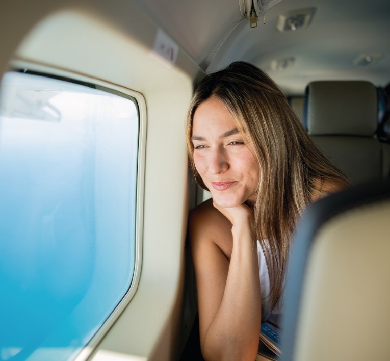 a woman looking out a window of an airplane