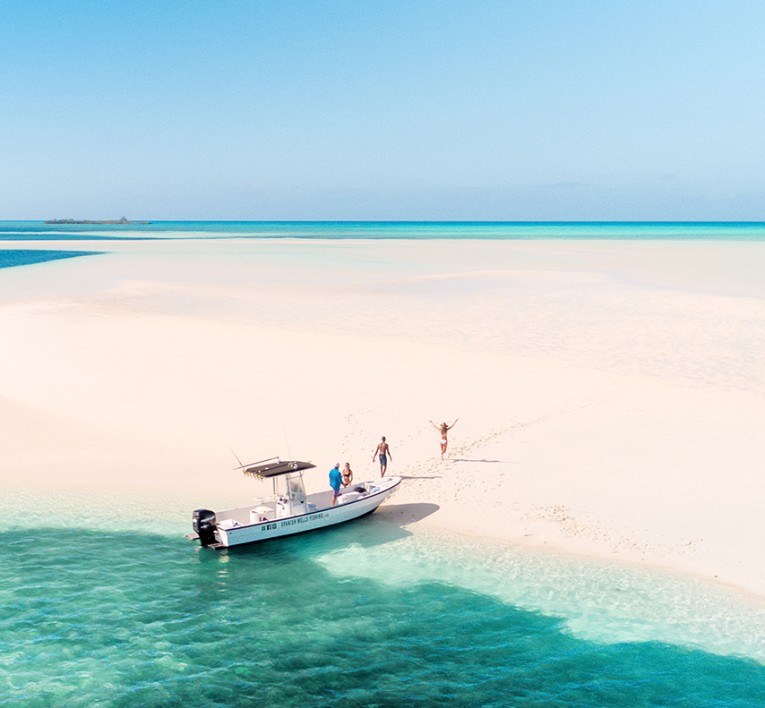 a group of people coming off a boat onto a sandbar