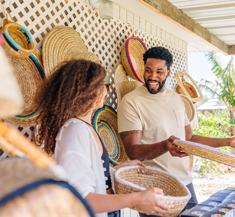 a man and woman holding straw woven baskets