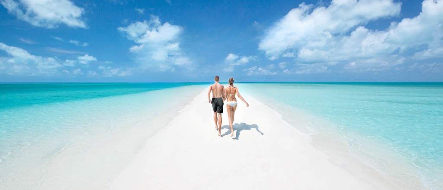 a man and woman walking on a beach