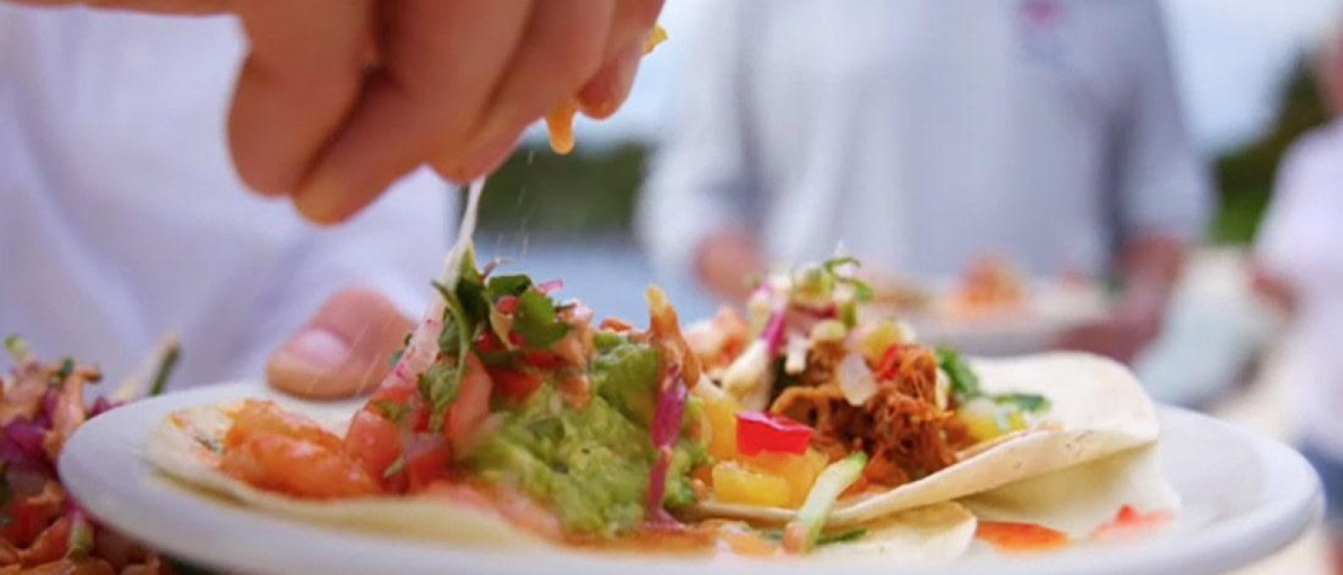 a person sprinkling food on a plate
