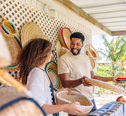 a man and a woman holding straw hats and baskets