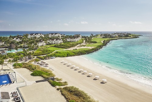a beach with white buildings and blue water