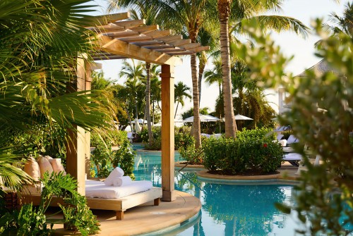 a pool with a lounge chair and palm trees