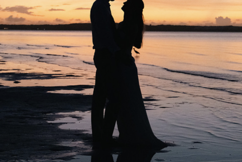 a silhouette of a man and woman on a beach