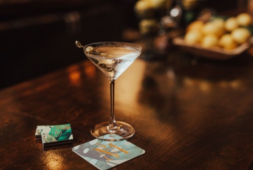 a martini glass with a green olive on top of it