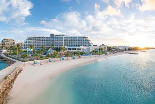 a beach with a building and a body of water