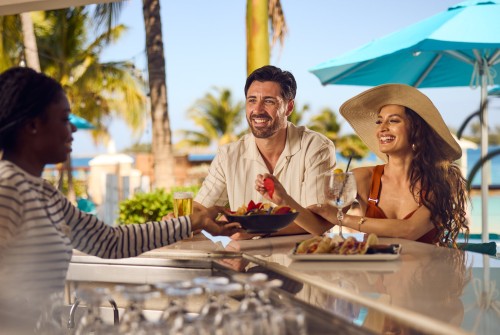 a woman handing a bowl of food to a man at a bar