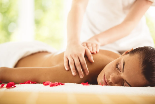 a woman lying down on a bed with red flowers