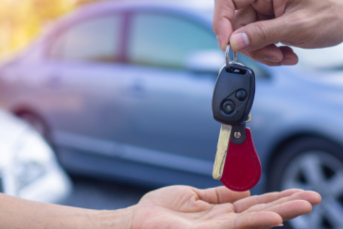 a person handing over a car key