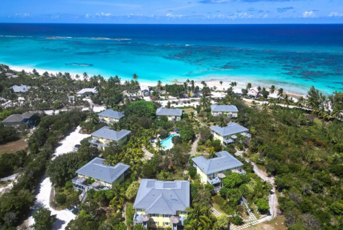 a group of houses surrounded by trees and a beach