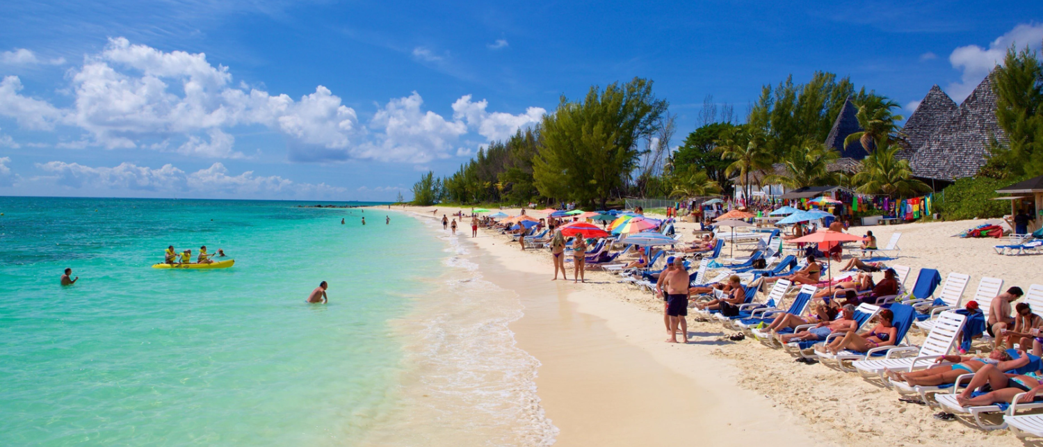 a beach with people and umbrellas