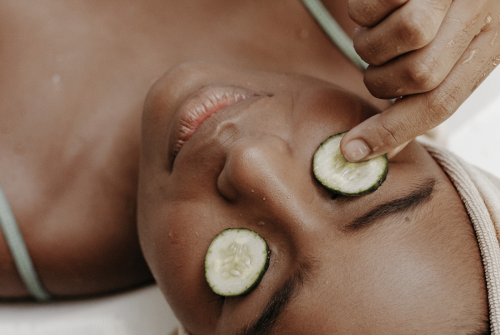 a woman with cucumbers on her eyes