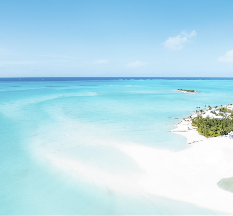 a beach with white sand and trees