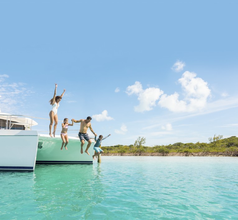 a group of people jumping off a boat