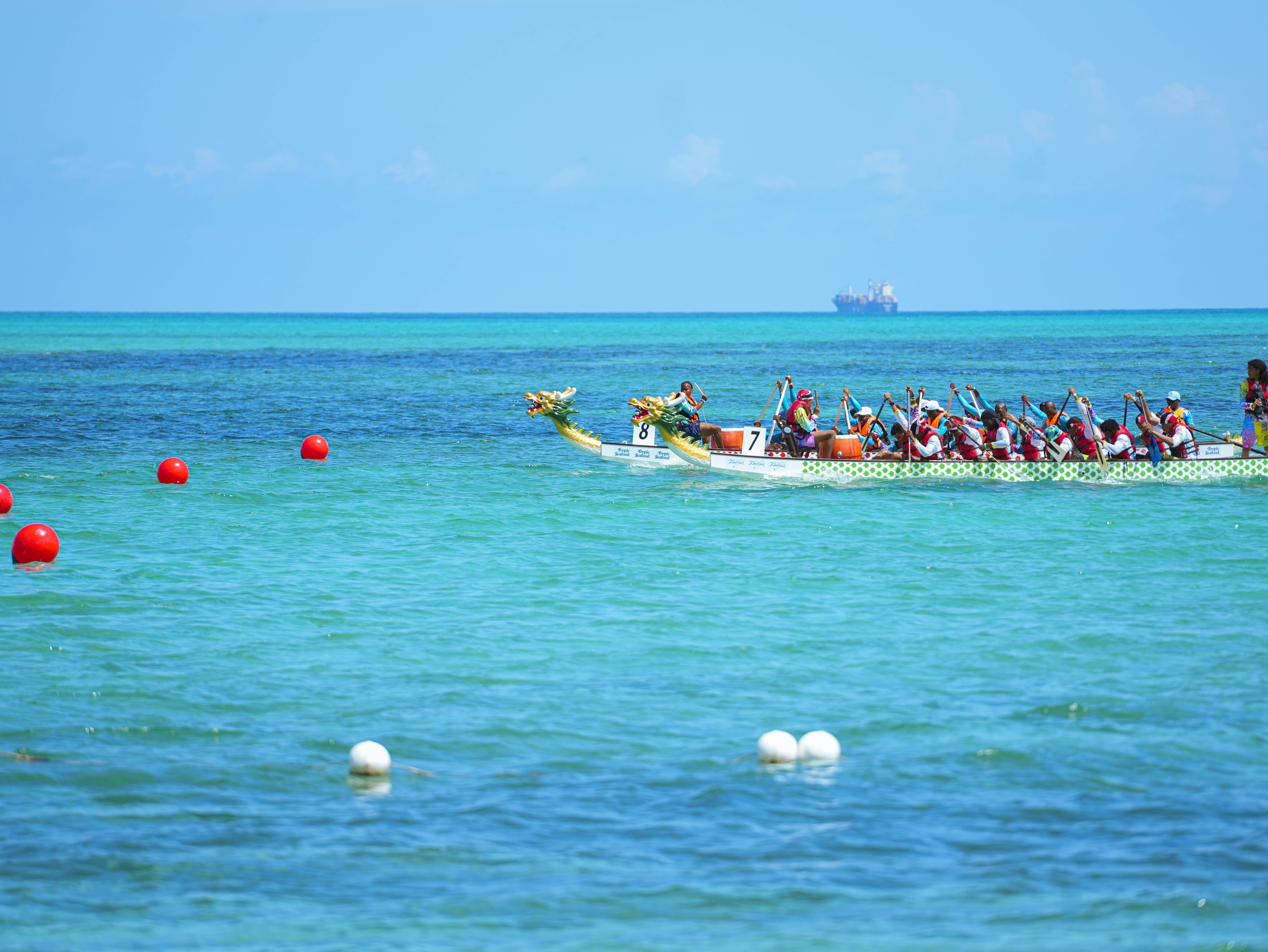 a group of people rowing a boat in the ocean