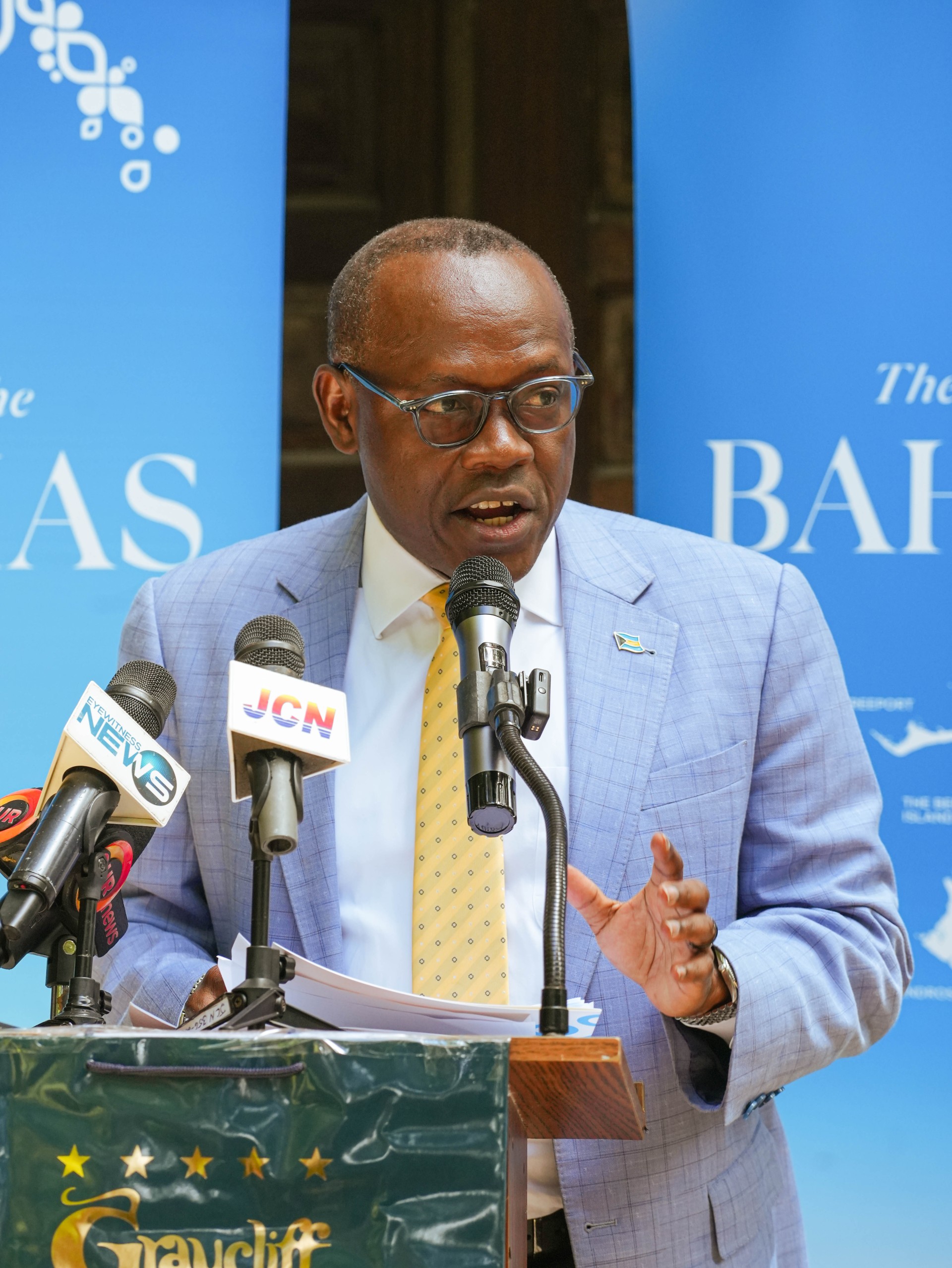 a man in a suit speaking into microphones