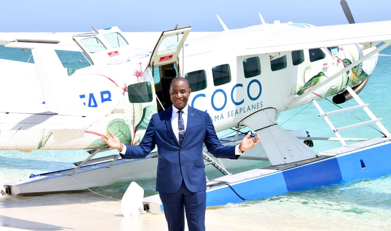 a person in a suit standing in front of a plane