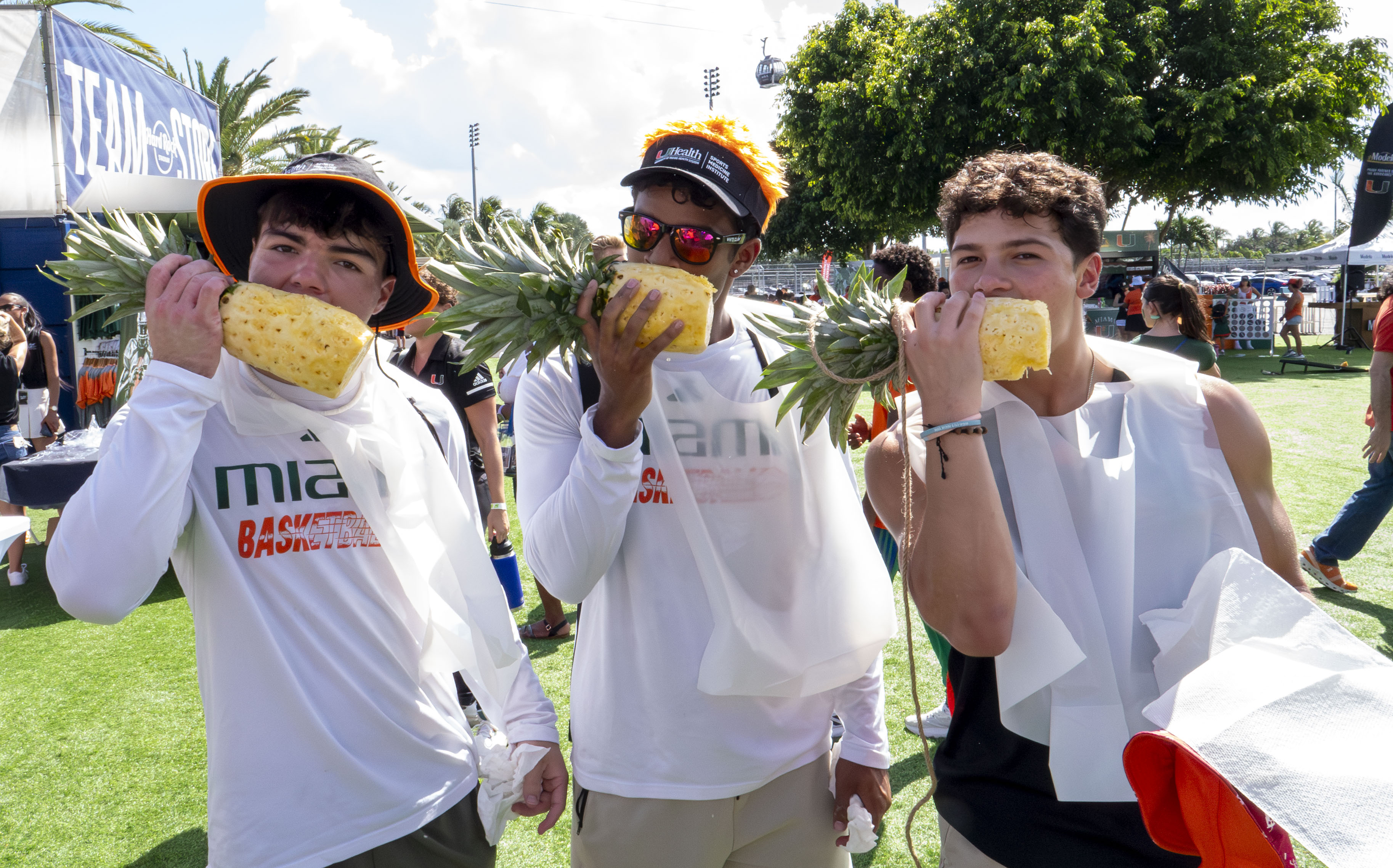 a group of people eating pineapples