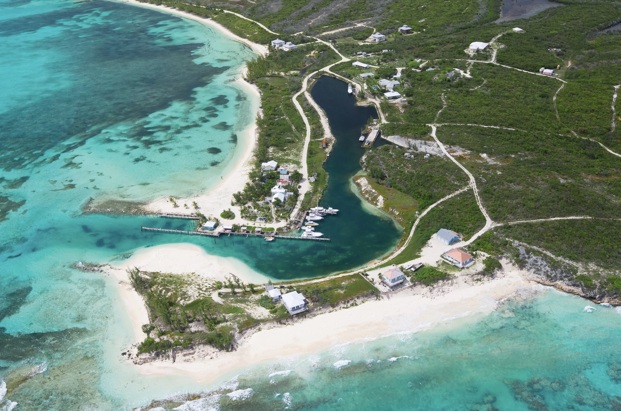 a aerial view of a beach with a body of water and houses